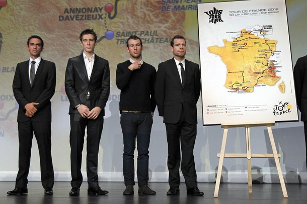 Riders pose next to the itinerary of the 2012 Tour de France cycling race during a presentation in Paris